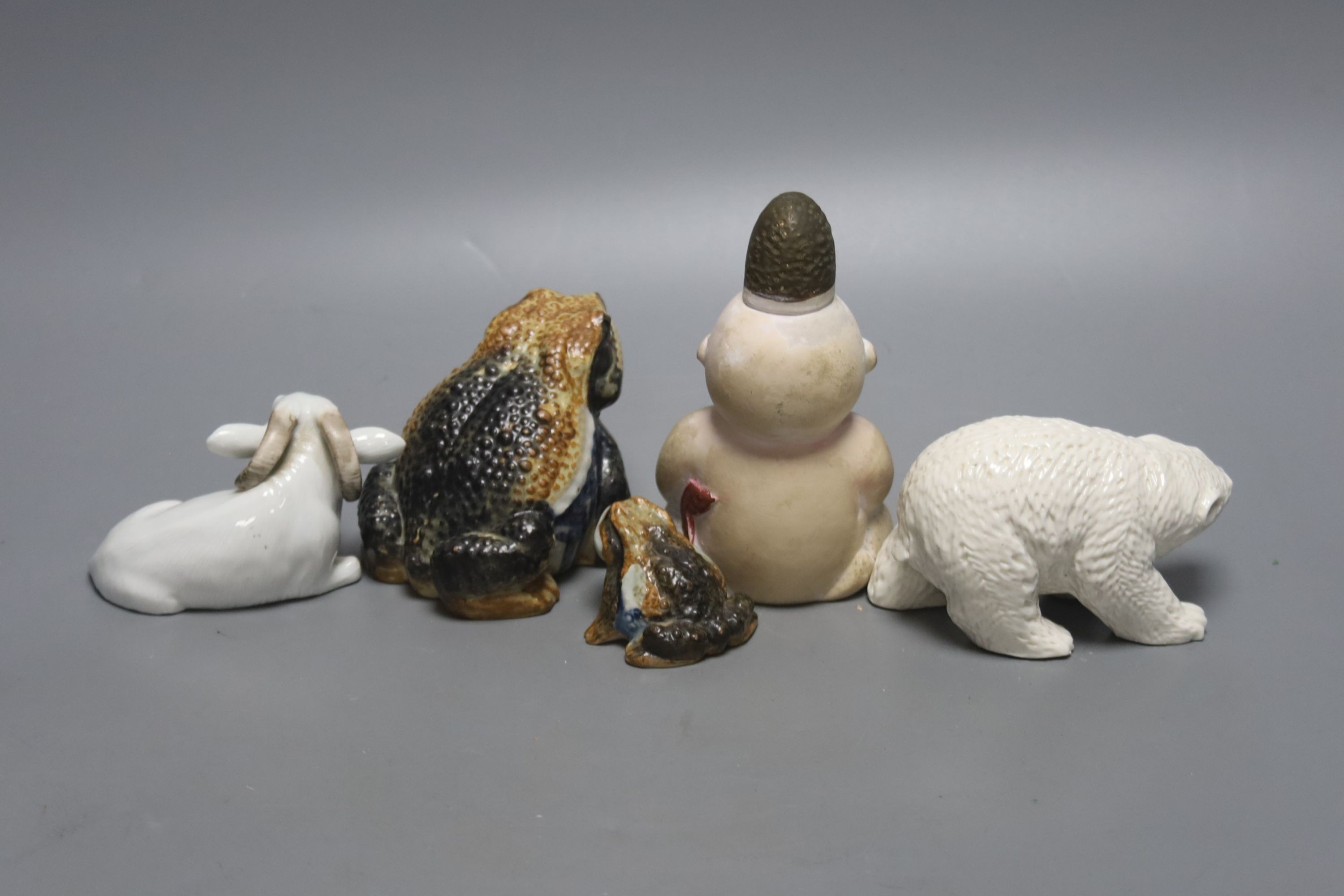 A Japanese Hirado porcelain figure of a polar bear, a Japanese porcelain figure of a ram, two figures of toads and a doll figure